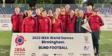 das Team steht hniter einer Bande mit der Aufschrift "2023 IBSA World Games Birmingham blind football"