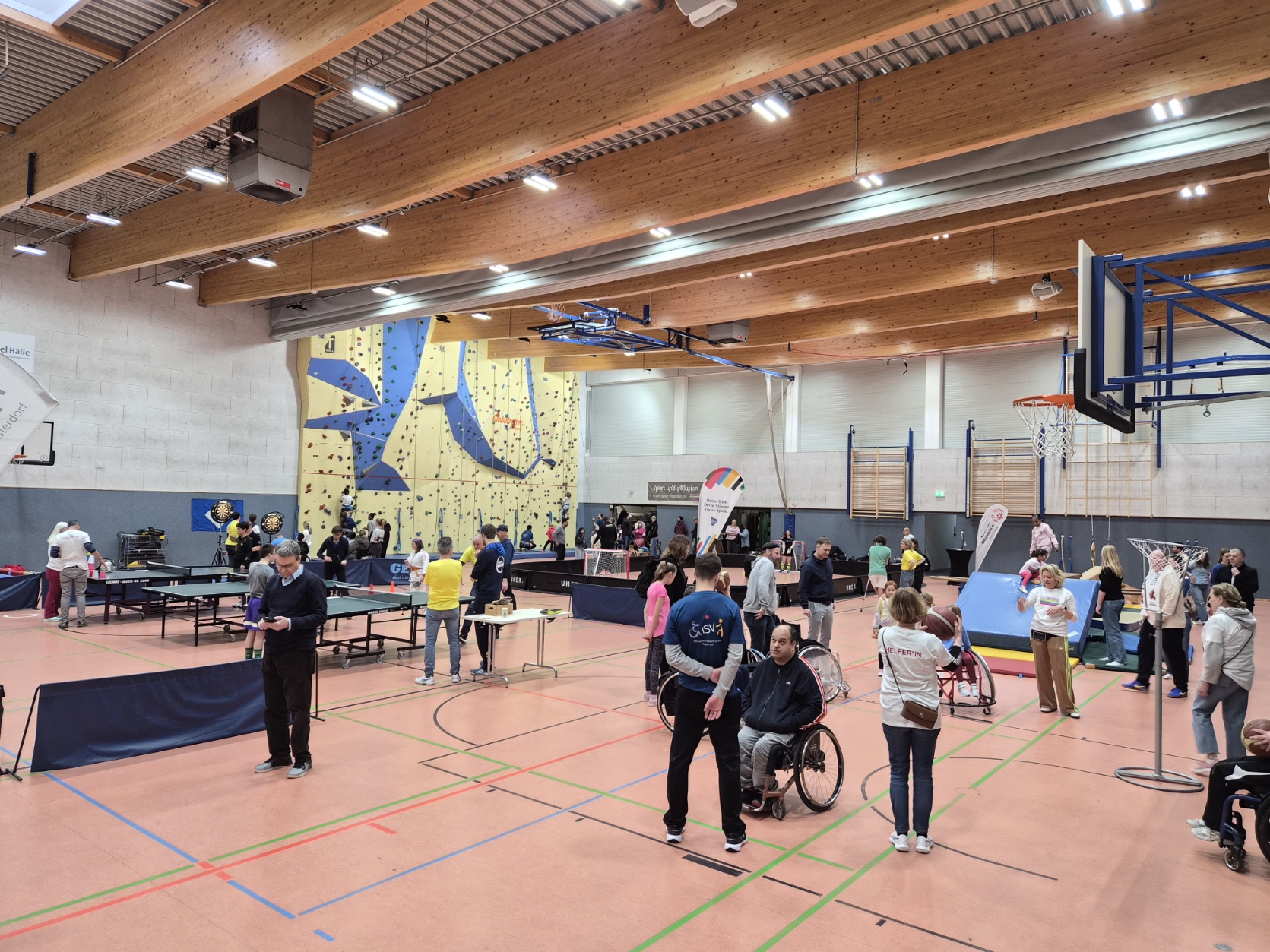 Blick in die Halle zeigt sporttreibende Menschen an verschiedenen Geräten