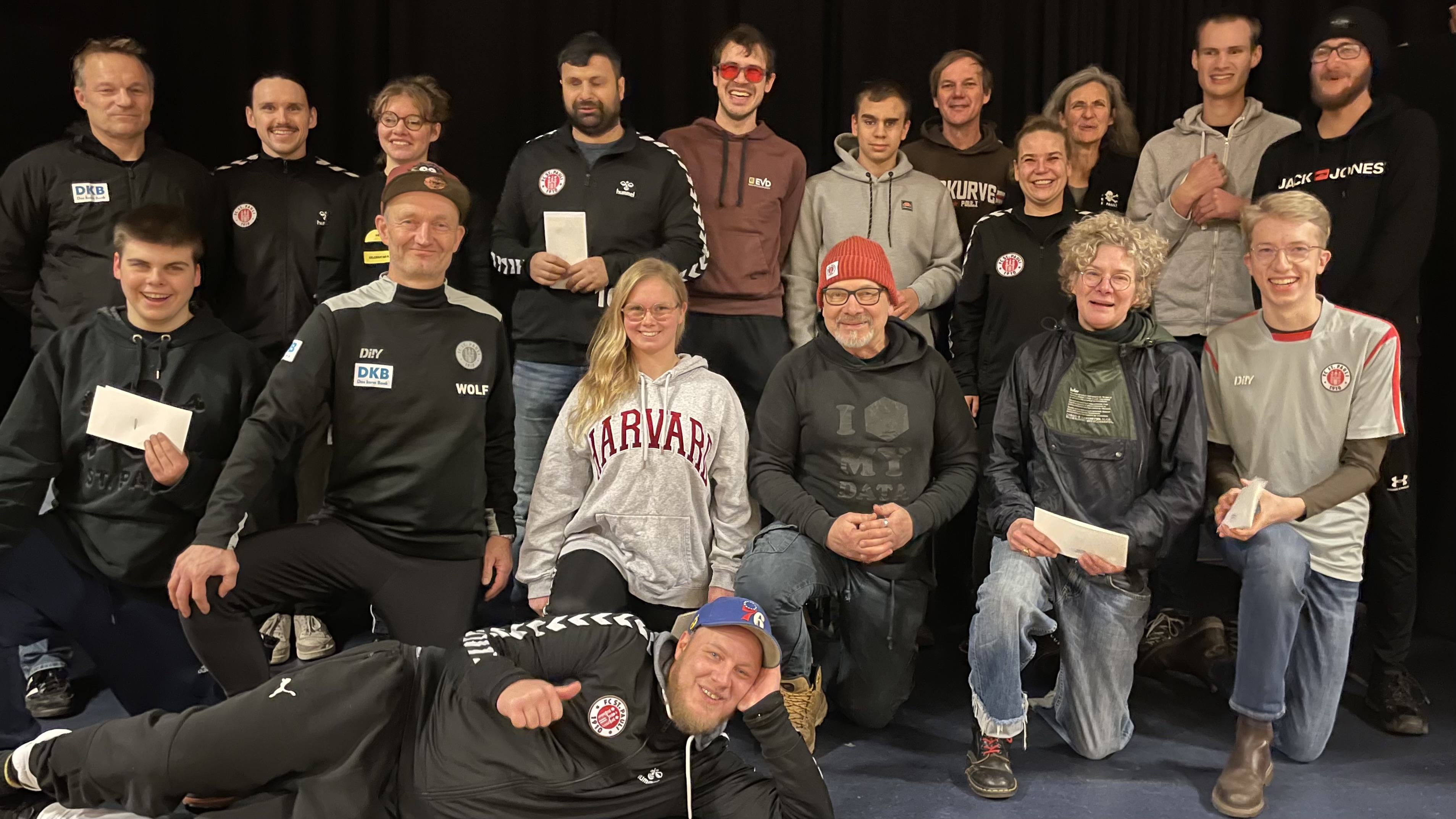 Gruppenfoto, aufgenommen nach der Ehrung, auf der Bühne der Aula des BZBS mit den anwesenden Teammitglieder*innen und Minke & Georg vom Ehrenrat. v.l.n.r.: Sven Gronau, Calvin Runge, Jonas Dawid, Thoya Küster, Wolf Schmidt, Serdal Çelebi, Jenny Dabelstein, Victor Pfaul (liegend), Paul Ruge, Georg, Natan Werner, Michael Hain, Jana Marquart, Minke, Antje Küster, Rasmus Narjes, Julius Kolbeck, Philipp Versen Foto: Thomas Ruge