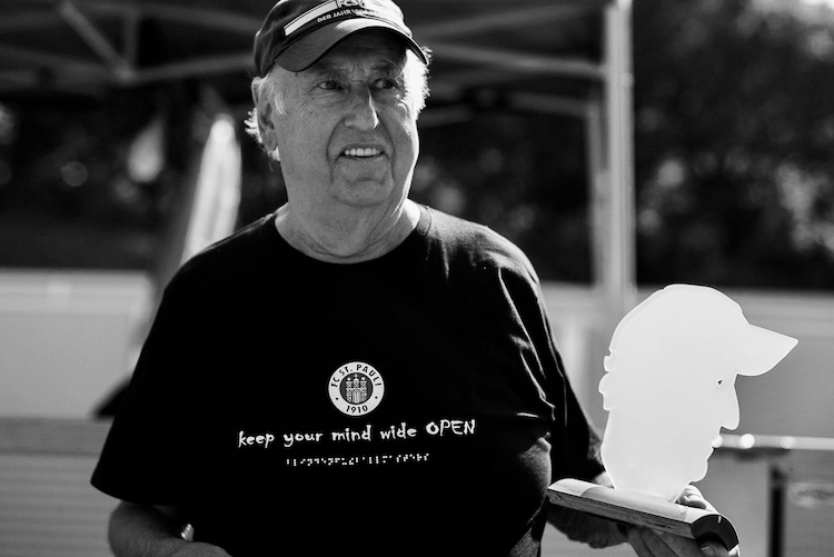 Dieter, in einem Masters-T-Shirt, hält den Masters-Pokal mit seinem Konterfei in der Hand und lächelt
