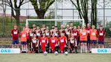 Das Liga-Team steht und kniet vor einem Tor mit DKB-Banden an dem Seiten. 