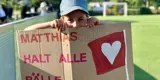 Ein kleiner Junge hält ein selbstgebasteltes Schild mit der Aufschrift "Matthias hält alle Bälle"